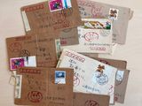 many envelopes with stamps on them sitting on a table