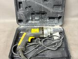 an electric drill in a black case with a cord
