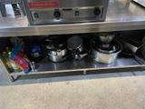 stainless steel counter with pots and pans on it in a kitchen