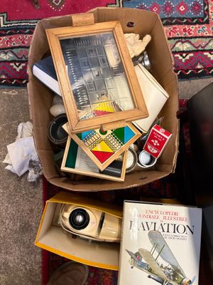 a box full of books and a camera on the floor