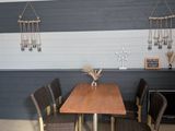 a table and chairs in a room with a striped wall behind it