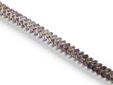 a close up of a purple and gold bracelet on a white surface