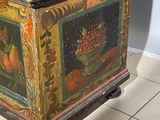 a wooden box with a painting on it sitting on a tile floor