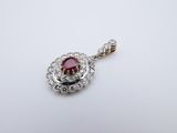 a ruby and diamond pendant on a white background