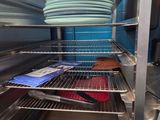 a rack with plates and pans on it in a kitchen