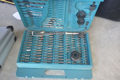 une boîte à outils bleue avec des outils sur le sol