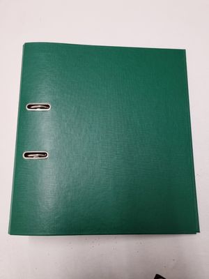 a green binder sitting on top of a table next to a pair of scissors
