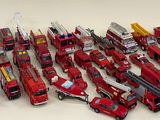 a lot of toy fire trucks that are lined up together