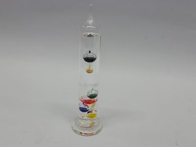 une image représentant un tube en verre rempli de billes de différentes couleurs