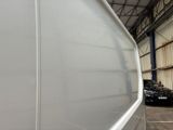 a white van parked in a garage next to a black car