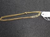 a close up of a gold chain with a tag on it