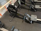 a row of rowing machines in a gym room