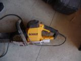 a yellow and black chainsaw on the floor next to a tire