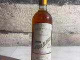 a bottle of liquor sitting on a table next to a stone wall