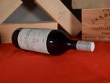 a bottle of wine sitting on a table next to a wooden box