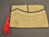 an image of a tan purse with a red tassel on it