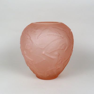 un vase rose orné d'un motif sur un fond blanc