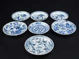 six assiettes bleues et blanches ornées de fleurs sur un fond noir