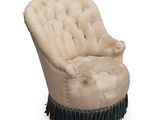 une chaise rembourrée avec des franges sur les pieds