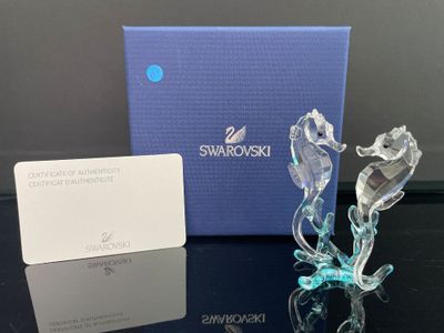une figurine en verre représentant un cheval et une carte de visite