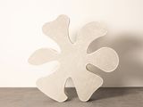 un grand objet blanc posé sur une table devant un mur