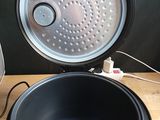 a black bowl sitting on a wooden table next to a toaster