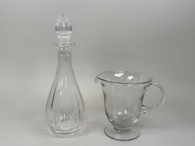 un pichet en verre et une cruche en verre posés sur une table