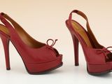 une paire d'escarpins rouges avec un nœud au talon