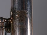 a close up of a silver saxophone with a black background