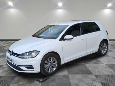 the white volkswagen golf is parked in a room with a checkered floor