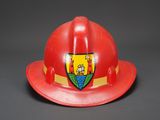 red fireman ' s hat with a crest on the side
