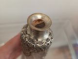 a person holding a silver vase in their hand