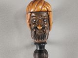 tête d'homme en bois sculptée à la main, coiffée d'un turban, posée sur une canne