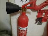 a fire extinguisor attached to a wall next to a fire hydrant