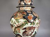 a large vase with a lid that has birds on it