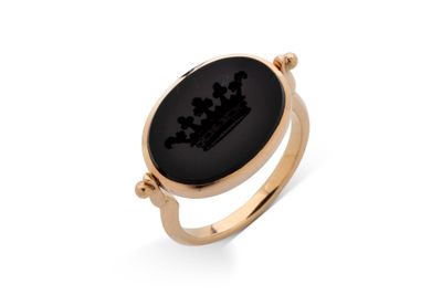 une bague en or ornée d'une pierre noire et d'une couronne
