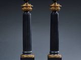 pair of black and gold candles with candlesticks on each side