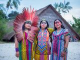 trois femmes vêtues de vêtements colorés, debout les unes à côté des autres