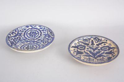 une paire d'assiettes bleues et blanches ornées de motifs sur un fond blanc