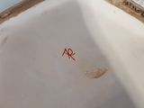 a close up view of a white porcelain bowl with red writing on it