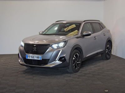 Le SUV argenté est garé dans une grande pièce au sol noir.