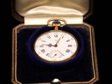 a small gold pocket watch inside of a velvet case
