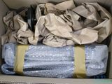 a cardboard box with a bunch of wrapped items in it
