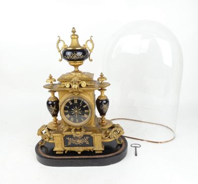 une horloge placée sous un dôme de verre sur une table