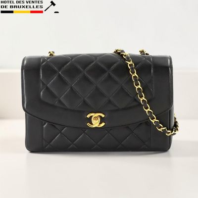 un sac Chanel noir avec des finitions dorées et une chaîne