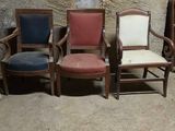 trois chaises placées côte à côte devant un mur en pierre