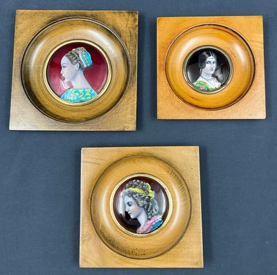 trois portraits de femmes dans des cadres dorés sur fond bleu