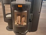 une cheminée au milieu d'une pièce où il y a beaucoup de bois