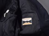 the back of a black jacket with a yellow and white patch on it