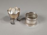 a silver cup and a silver spoon sitting on a table